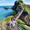 Tourists crossing the Carrick-a-Rede Rope Bridge over a cliffside gap
